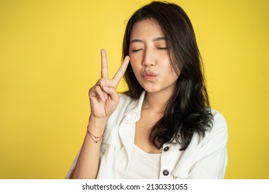 Asian Woman With Cute Hand Gesture Making V Shape On Finger