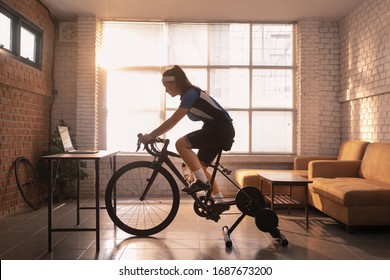 Asian woman cyclist. She is exercising in the house.By cycling on the trainer and play online bike games - Shutterstock ID 1687673200