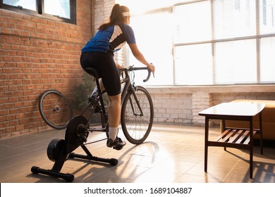 Asian woman cyclist. She is exercising in the house.By cycling on the trainer 