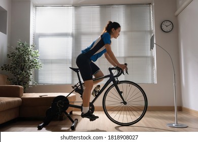 Asian Woman Cyclist. She Is Exercising In The Home.By Cycling On The Trainer And Play Online Bike Games.She Stood Up Spinning