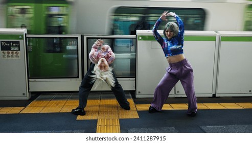 Asian woman, dancing and railway station by train for energy, art or underground performance in subway. Female person, friends or hip hop dancers in Japan, practice or training together by transport