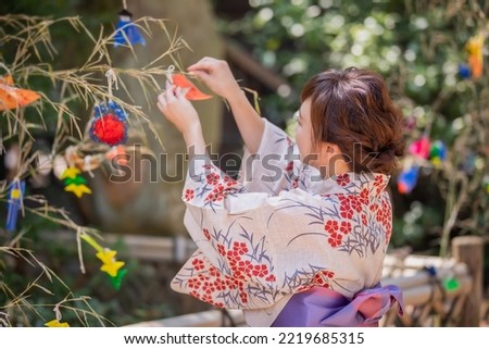 Asian woman decorating Tanabata strips