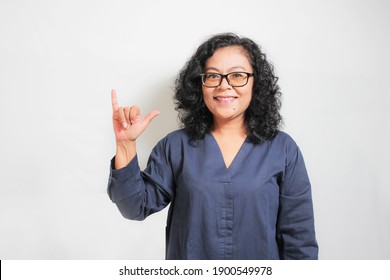 an Asian woman demonstrating the letter Y. sign language symbol for deaf human with white background. isolated