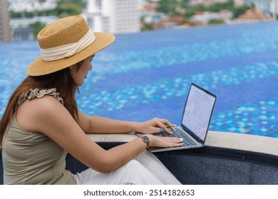 Asian woman digital nomad freelancer work typing laptop on online meeting Remote work happy working digital nomad in sunny blue water pool - Powered by Shutterstock