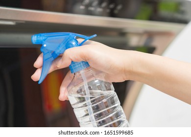 Asian Woman Disinfecting And Cleaning The Kitchen