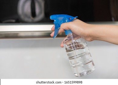 Asian Woman Disinfecting And Cleaning The Kitchen