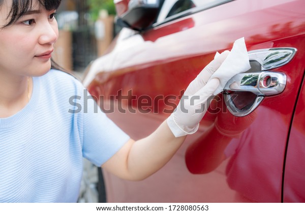 Asian woman disinfecting door handle of red car by
disinfectant disposable wipes from box. Prevent the virus and
bacterias, Prevent covid19, corona virus, Alcohol Sanitizer.
Hygiene concept at home.