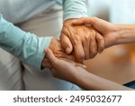 Asian woman doctor consoling senior patient with holding her hand. Private duty nurse visit and take care elderly woman on the bed at home. Home medical caregiving service and health insurance concept