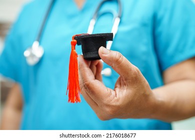 Asian Woman Doctor Holding Graduation Hat In Hospital, Medical Education Concept.