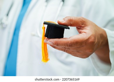 Asian Woman Doctor Holding Graduation Hat In Hospital, Medical Education Concept.