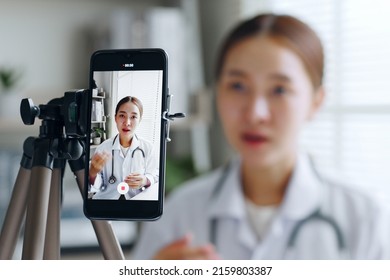 Asian woman doctor making online live streaming broadcast talking over camera recording in hospital, medical and healthcare blogger, vlogger concept - Powered by Shutterstock