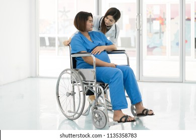 Asian woman Doctor talking to young pregnant woman in wheelchair at hospital. Beautiful asian doctor taking care of patient in wheelchair.
 - Powered by Shutterstock