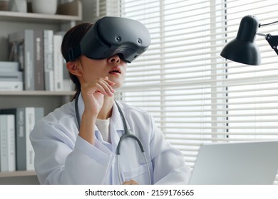 Asian Woman Doctor Using 3d VR Virtual Reality To Analyze Medical Exam, Report In Medical Office Hospital