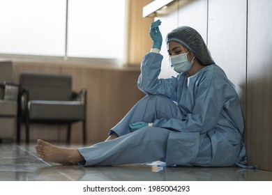 Asian Woman Doctor Wearing Surgical Face Mask Sitting On Thr Floor Tired From Work Because Impact From Covid-19 Pandemic Outbreak, Sadness Healthcare Worker Woman, Medical And Healthcare Concept