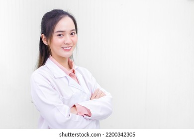 Asian Woman Doctor Who She Has Black Long Hair, Wear Stethoscope And A White Lab Coat As Uniform While Arm Cross At Office Room In Hospital In Health Care,new Normal And Coronavirus Protection Concept