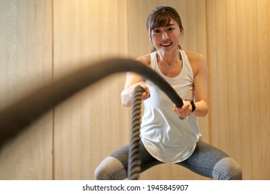 Asian Woman Doing A Battle Rope In A Training Gym