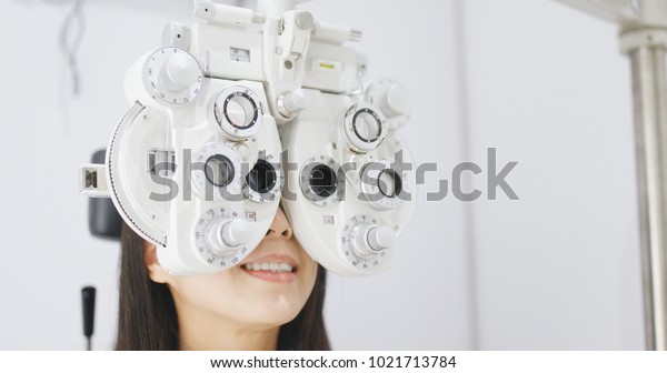 Asian Woman doing eye\
test in clinic 
