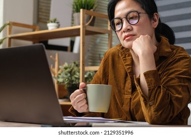 Asian Woman Drink Coffee Cup And Watching Live Streaming On Laptop When Work At Home