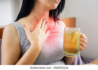 Asian woman drinking beer having problem with GERD , acid reflux, and heartburn with gastritis from alcohol 
