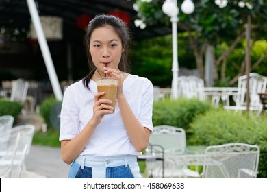 Asian Woman Drinking Ice Coffee Outdoors