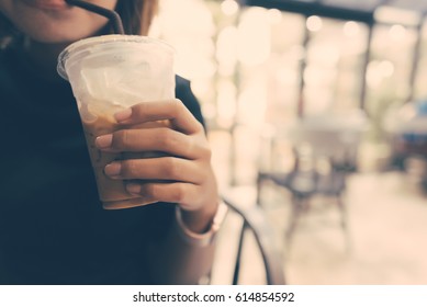 Asian Woman Drinking Ice Coffee In Coffee Shop In Selective Focus With Vintage Filter.