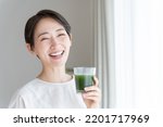 Asian woman drinking vegetable juice