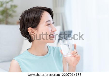 Asian woman drinking water after exercise