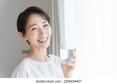 Asian Woman Drinking Water From A Glass