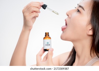 Asian Woman Dripping THC Oil Into Her Mouth. Close Up Asian Women Taking THC Oil For Sleep. Medical Cannabis. Vitamins And Supplements New Choice For Health.