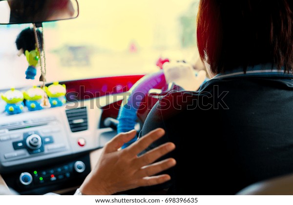 Asian woman\
drive the sedan at the sun set\
time
