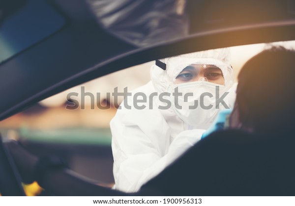 Asian Woman Drive\
Thru Covid-19 Testing With PPE Medical Staff, COVID testing temp\
while checking in cars