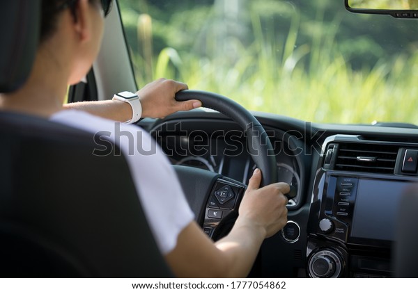 Asian
woman driver driving off road car in the
nature