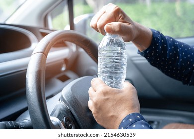 Asian Woman Driver Holding Bottle For Drink Water While Driving A Car. Plastic Hot Water Bottle Cause Fire.