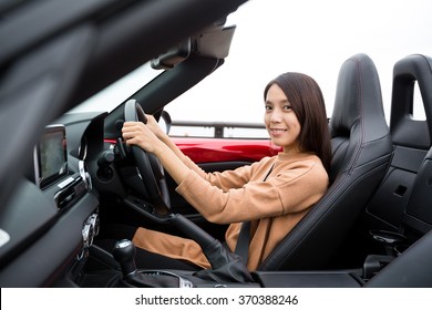 Asian Woman driving cabriolet