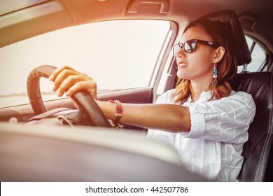 Asian Woman Driving A Car In A Happy Mood.