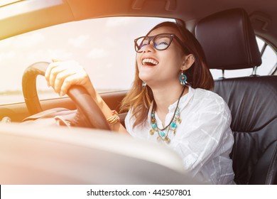 Asian Woman Driving A Car In A Happy Mood.