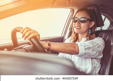 Asian Woman Driving A Car In A Happy Mood.