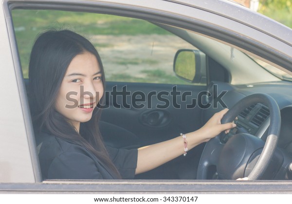 Asian woman driving\
car in vintage style