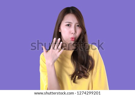 Asian woman eating hot and spicy food, yellow t-shirt clothing, purple background