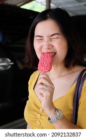 Asian Woman Eating Ice Cream With Delicious And Happy Expression On Her Face.