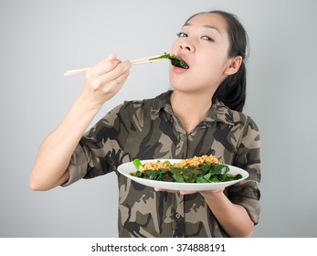 Asian Woman Eating Kale Fried In Oyster Sauce.