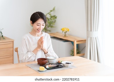 Asian woman eating a meal - Powered by Shutterstock