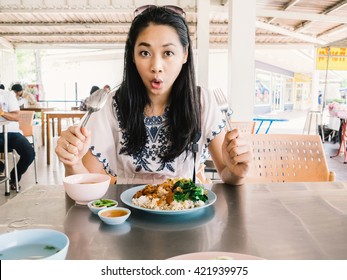 Asian woman is eating Stewed pork leg on rice.