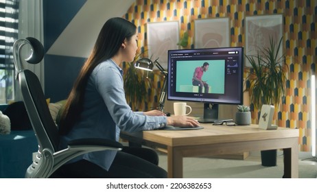 Asian Woman Editing Photo In Photoshop For Customer On Personal Computer While Sitting At The Table At Home Office And Working Remotely