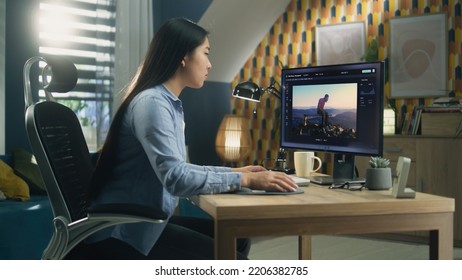 Asian Woman Editing Photo In Photoshop For Customer On Personal Computer While Sitting At The Table At Home Office And Working Remotely