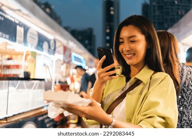 Asian woman enjoy eating fries street food at night market. Traveler Asian blogger women Happy tourists Beautiful female with Traditional thailand bangkok food. - Powered by Shutterstock