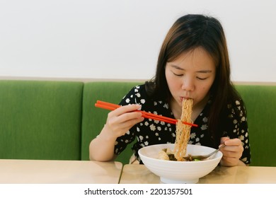 Asian Woman Enjoy Eating Noodle In The Restaurant