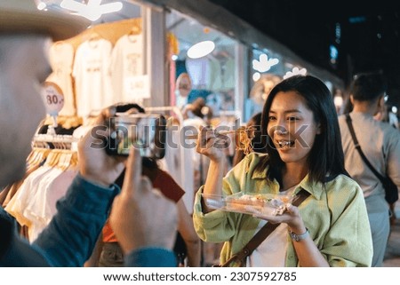 Asian woman enjoy eating noodles street food at night market. Traveler Asian blogger women Happy tourists Beautiful female with Traditional thailand bangkok food.