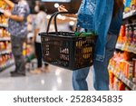 Asian woman enjoy urban lifestyle shopping at department store. Attractive girl holding supermarket basket choosing, checking price and buy food and grocery on shelf in supermarket at shopping mall.