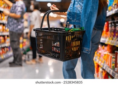 Asian woman enjoy urban lifestyle shopping at department store. Attractive girl holding supermarket basket choosing, checking price and buy food and grocery on shelf in supermarket at shopping mall. - Powered by Shutterstock